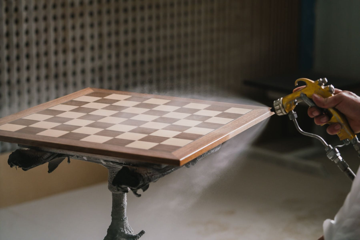 Walnut chess board being spray-varnished at the Rechapados Ferrer workshop, La Garriga